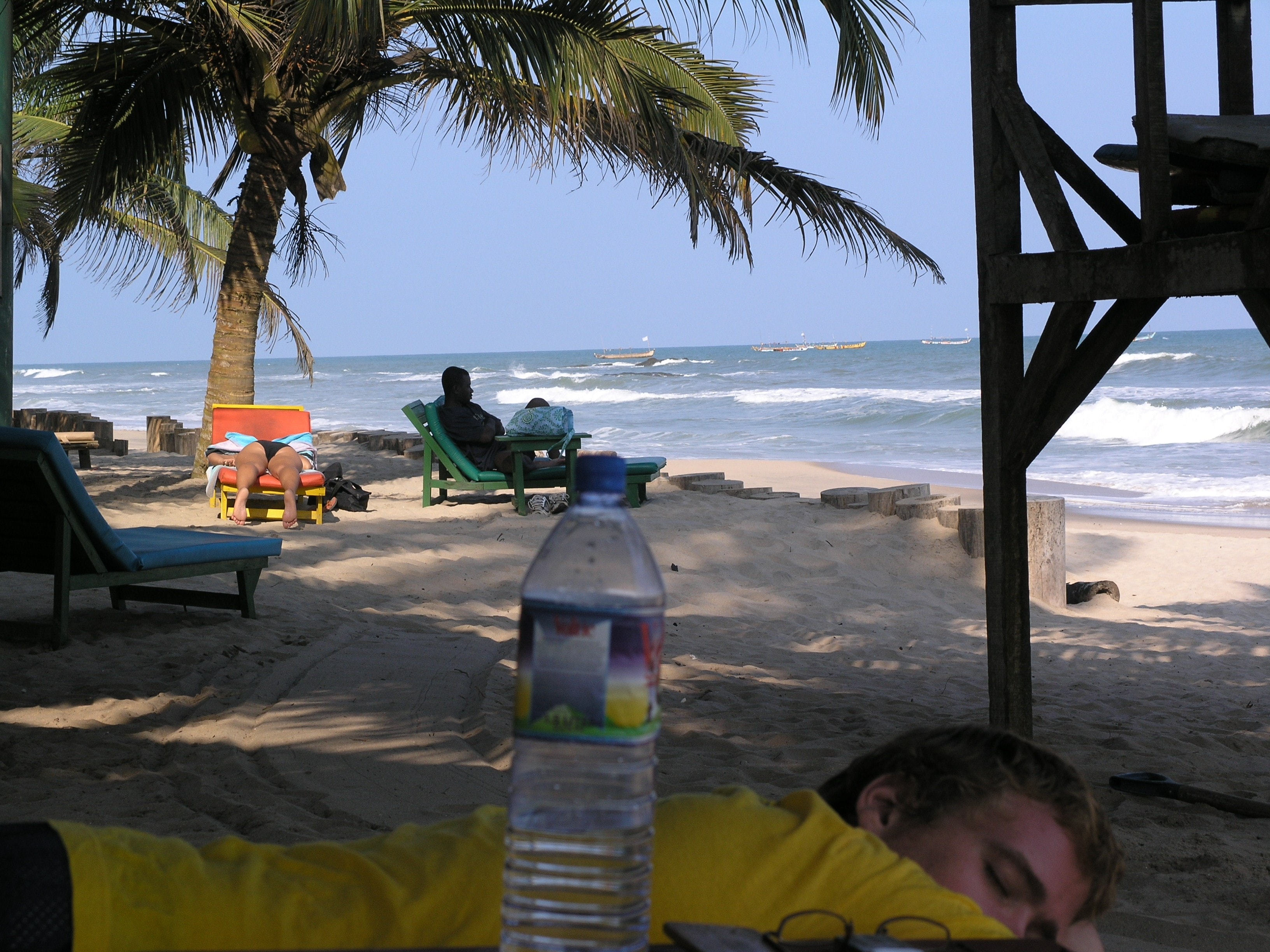 Beach scene at Anomabu with palm trees and fishing boats