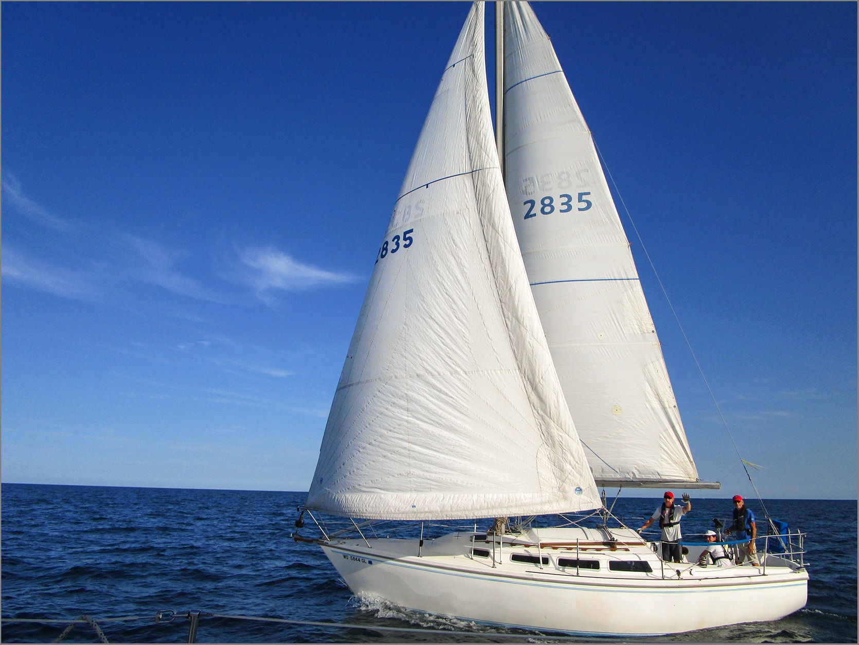 Boat 2835 white hull crew waving bright blue sky